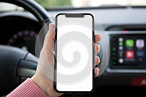 Women hand holding phone with screen in the car