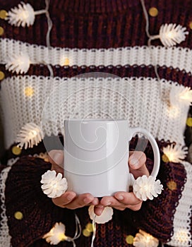 Women hand holding white ceramic coffee cup with light decoration. mockup mug for creative advertising text message content