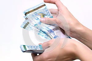 The women hand holds the national currency of Kazakhstan tenge