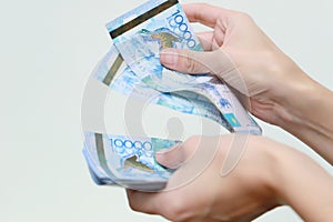 The women hand holds the national currency of Kazakhstan tenge