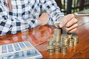 Women hand put money coins to stack of coins. Business Growth co