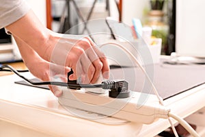 Women hand putting the electric plug on the electricity supply connection