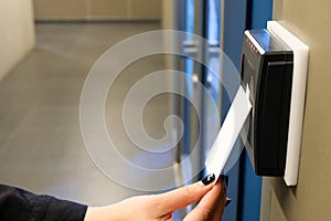 Women hand reaching to use RFID key card to access to office building area and workspace. In building security only for authorized