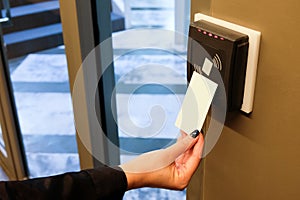 Women hand reaching to use RFID key card to access to office building area and workspace. In building security only for authorized