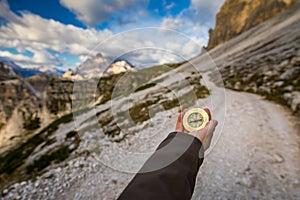 Women hand using a compass in the mountains, travel concept. Han
