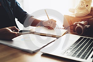 Women hand using smart pone with note paper at home office table