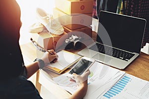 Women hand using smart pone with note paper at home office table photo