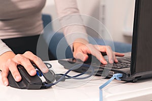 Women hand is using the USB mouse while working on laptop