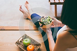 Woman hands holding and eating healthy salad for breakfast in the morning