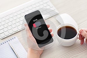 Women hands holding phone with low charged battery on screen