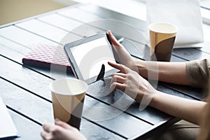 Women hands holding tablet with white blank screen in cafe. Close-up