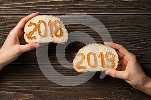 Women hands holding two sandwiches with red caviar in the shape of 2018 and 2019 numbers