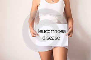 Women hands holding a white sign with the word leucorrhoea disease on white background photo