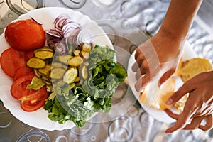 Women hands lay out sliced fruits on a plate. Top view