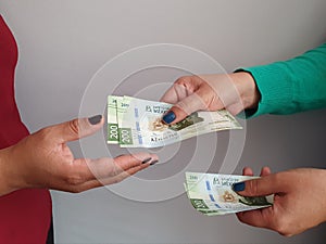 women hands paying and receiving mexican money