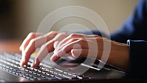 Women hands are printing on the laptop keyboard. Detail shot