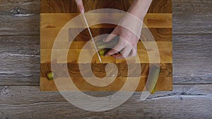 Women hands sliced pickled cucumbers