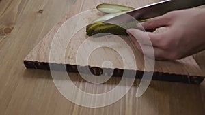 Women hands sliced pickled cucumbers close-up