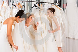 Women having fun during bridal dress fitting in shop