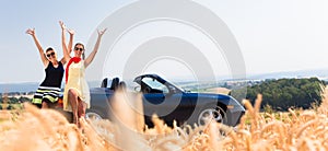 Women having joyride in convertible car having rest