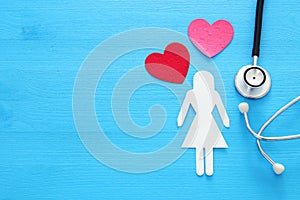 women healf Insurance . concept image of Stethoscope and female figure on wooden table. top view.