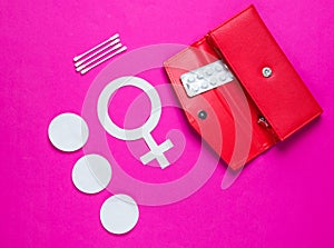 Women Health. Products for feminine hygiene, self-care, female gender symbol on pink background. Ear sticks, pads, pills in purse