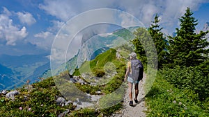 women hiking in the Swiss Alps mountains at summer vacation with a backpack and hiking boots