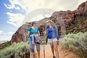 Women hiking together in a beautiful red rock canyon photo
