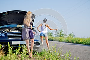 Women hitchhiking after a breakdown