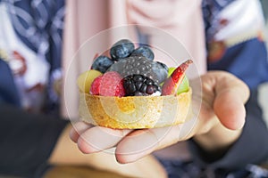 women holding a berry fruit tart cake