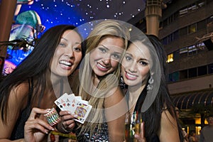 Women Holding Casino Chips, Playing Cards And Champagne Glass