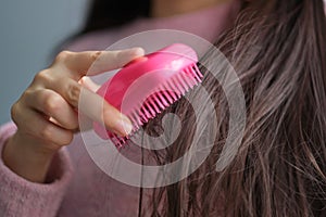 women holding messy hair in hands, Combing with brush and pulls long hair, Long disheveled hair
