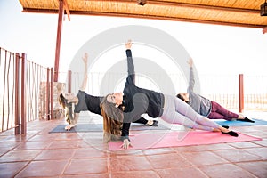 Women holding the side plank yoga pose