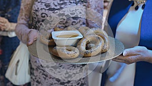 Women are holding a tray with delicious bagels in their hands.