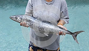 Women holding a wahoo or king mackerel fish photo