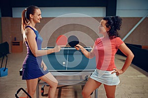 Women holds ping pong rackets, table tennis