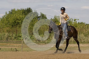 Women is horse riding - red hair girl in summer meadow