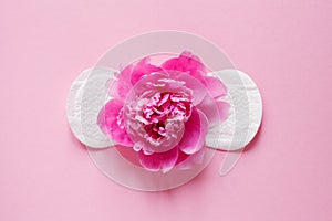 Women intimate hygiene product, sanitary pad and beautiful fresh peony flower on pink background