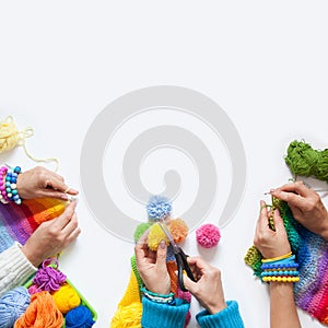 The women knit and crochet colored fabric. View from above.