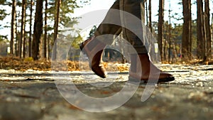 Women legs hiking  terrain in slow motion. Feet in chelsea boots walking on spring road.