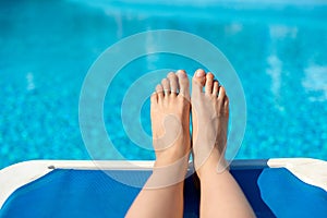 women legs pedicure nails splashing in tropical swimming summer pool