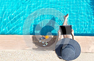 Women lifestyle play laptop relaxing near luxury swimming pool sunbath, summer day at the beach resort in the hotel.