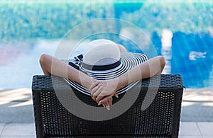 Women lifestyle relaxing near luxury swimming pool sunbath, summer day at the beach resort in the hotel