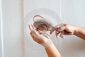 Women with long hair on the hair brush show hair loss problems