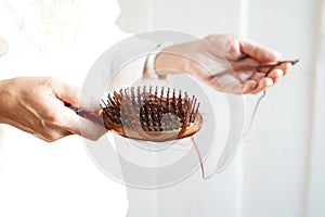 Women with long hair on the hair brush show hair loss problems