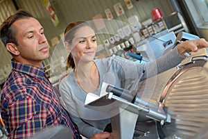 Women looking at industrial meat slicer