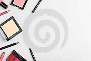 Women makeup cosmetics elegant background with place for text. Facial powder, eyeliner pencil, blusher border on light grey