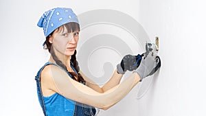 Women in the male profession: A girl repairs an electrical switch with a screwdriver and pliers.