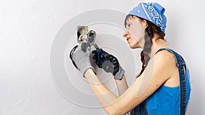 Women in the male profession: A girl repairs an electrical switch with a screwdriver and pliers.