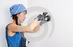 Women in the male profession: A girl repairs an electrical switch with a screwdriver and pliers.